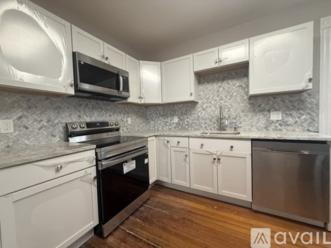 A kitchen with white cabinets and a black oven.