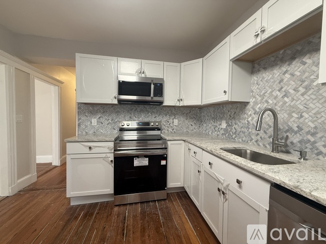 A kitchen with white cabinets and a black stove top oven.