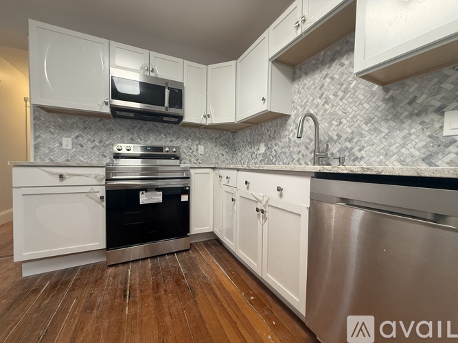 A kitchen with white cabinets and a stainless steel dishwasher.