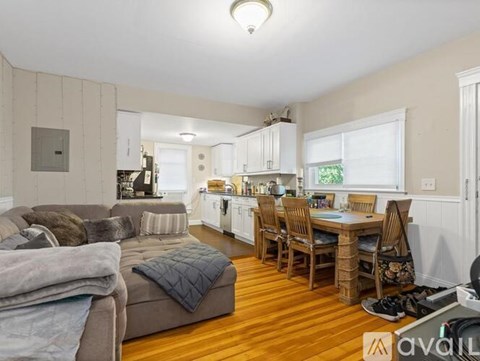 A living room with a grey couch and a wooden dining table.