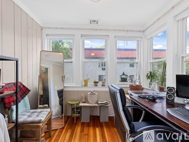 A room with a desk and a chair in front of a window.