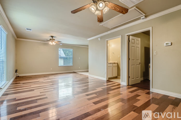 A room with wooden flooring and a ceiling fan.