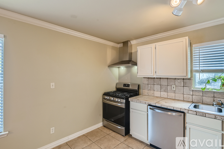 A kitchen with a black stove top oven and white cabinets.