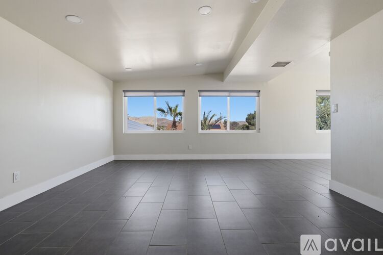 A spacious room with large windows overlooking a desert landscape.