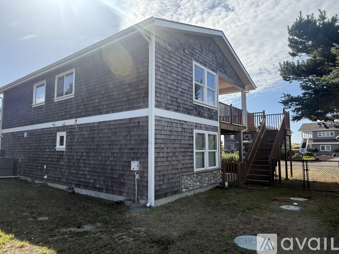 A house with a grey exterior and a white trim is available for rent.