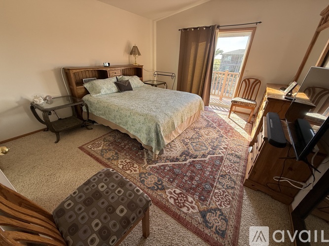 A bedroom with a large bed, a chair, and a desk.