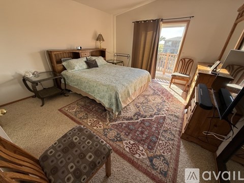 A bedroom with a large bed, a chair, and a desk.