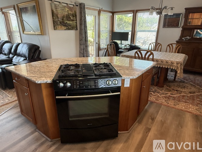 A kitchen with a granite countertop and a stove top oven.
