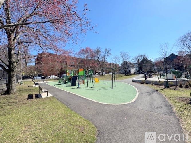 A park with a paved path and a playground.