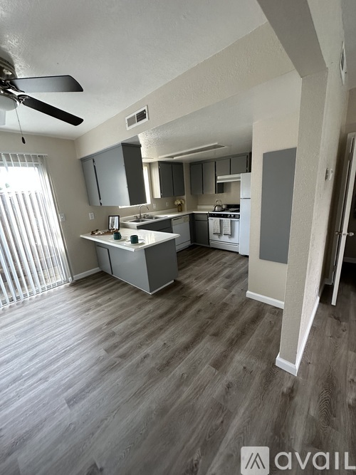 A kitchen with a fan on the ceiling and a countertop with a sink.