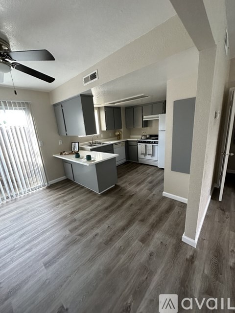 A kitchen with a fan on the ceiling and a countertop with a sink.