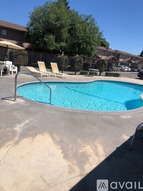 A pool with a chair and umbrella in the background.