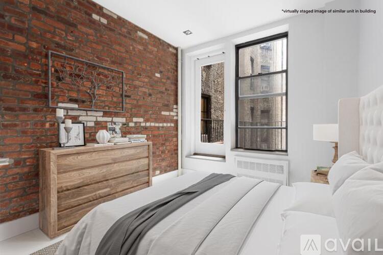 A bedroom with a brick wall and a large bed.