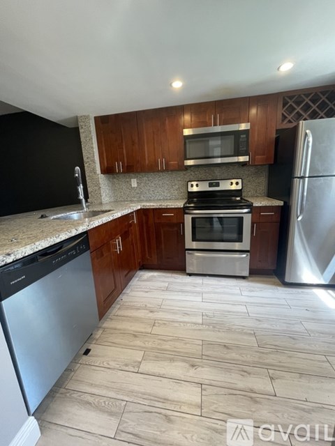 A kitchen with a stove top oven, microwave, refrigerator, and dishwasher.