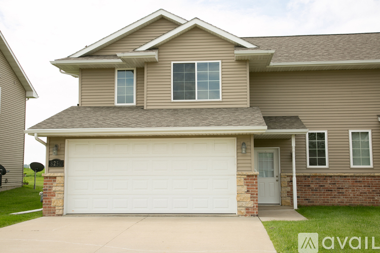 A house with a garage door and a brick pillar.