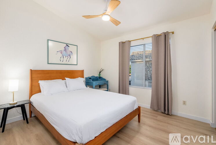 A bedroom with a large bed and a ceiling fan.