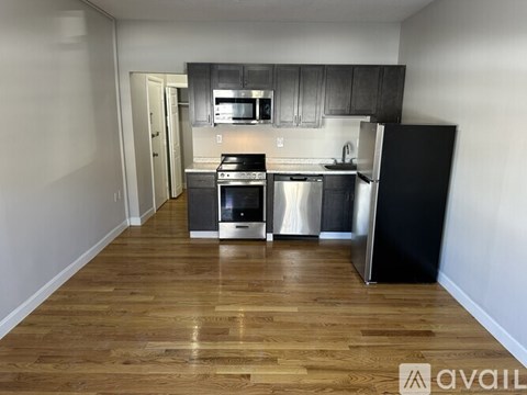 A kitchen with a black fridge, stainless steel oven and microwave.