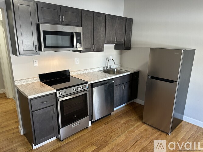 A kitchen with a stove top oven, microwave, and refrigerator.