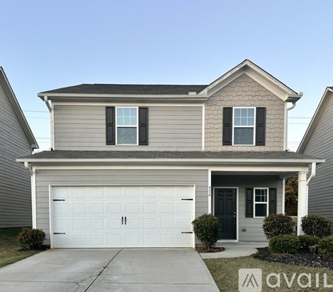 A two-story house with a garage and a front door.