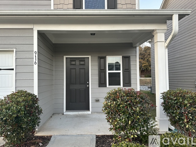 A grey house with a black door and windows.