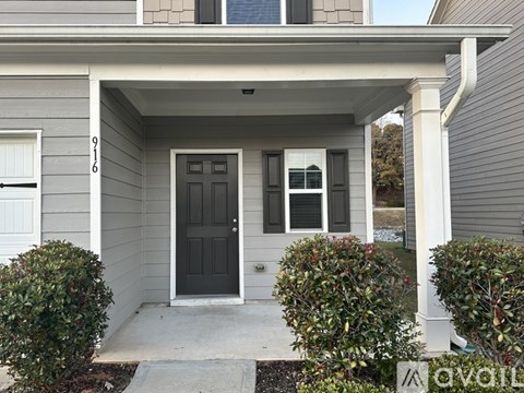 A grey house with a black door and windows.