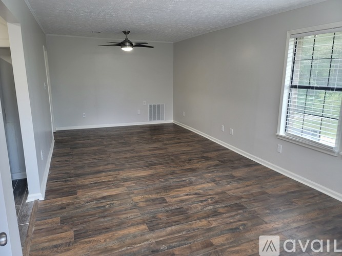 A room with wooden flooring and a ceiling fan.