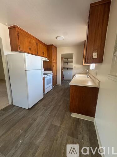 A kitchen with wood cabinets and a white refrigerator.