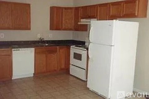 A kitchen with white appliances and brown cabinets.