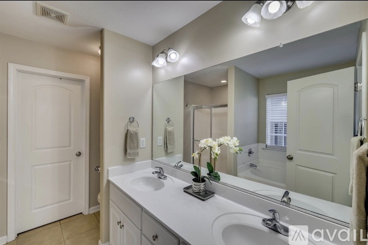 A bathroom with a white sink and a large mirror.