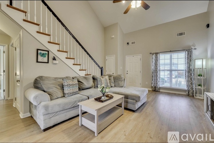 A living room with a grey couch and a wooden coffee table.