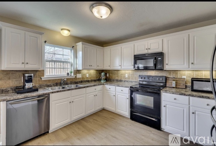 A kitchen with white cabinets and a black oven.