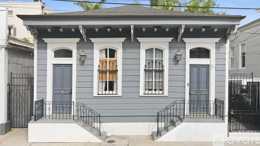 A grey house with a black iron fence.