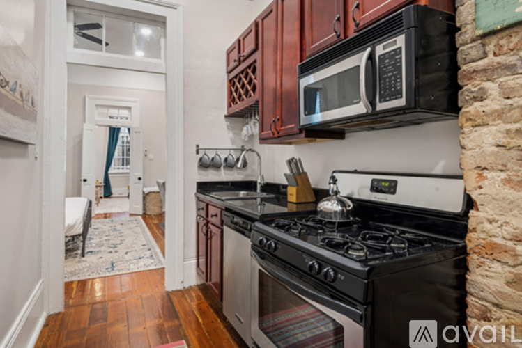 A kitchen with a black stove top oven and a black microwave above it.