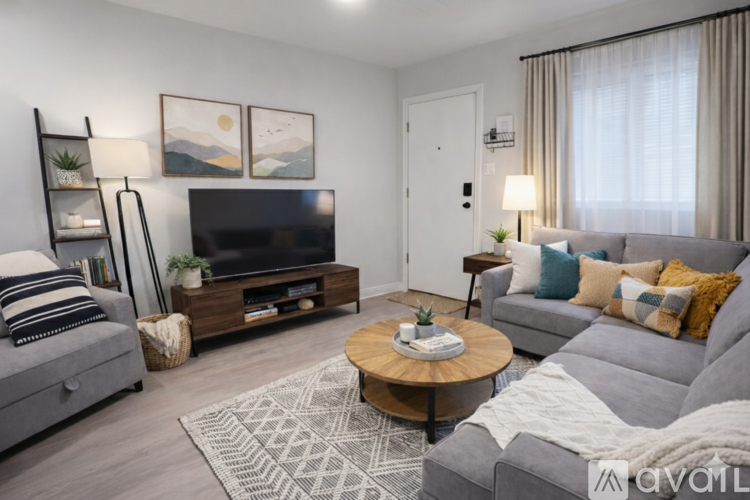 A living room with a grey couch, a coffee table, and a television.