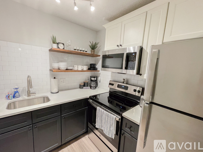 A kitchen with a sink, stove, and refrigerator.
