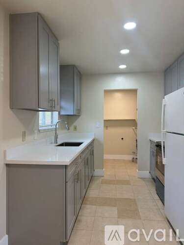 A kitchen with a white fridge and cabinets.