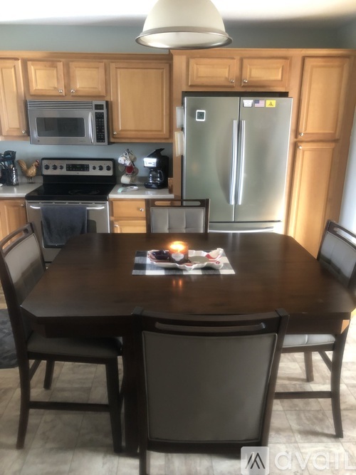 A kitchen with a table and chairs.