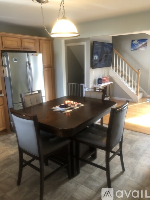 A dining room with a wooden table and chairs.
