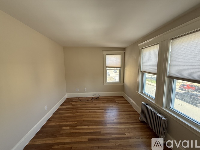 A room with wooden floors and two windows.