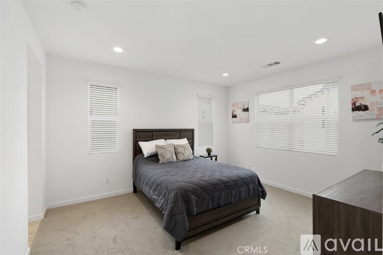 A bedroom with a large bed and a carpeted floor.