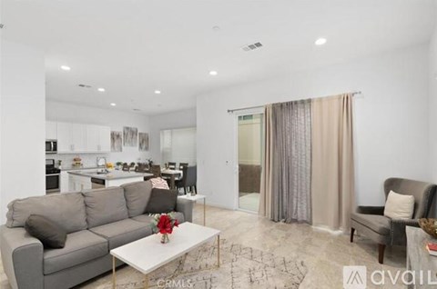 A living room with a grey couch and a white coffee table.