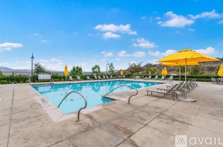 A large outdoor pool area with sun loungers and umbrellas.