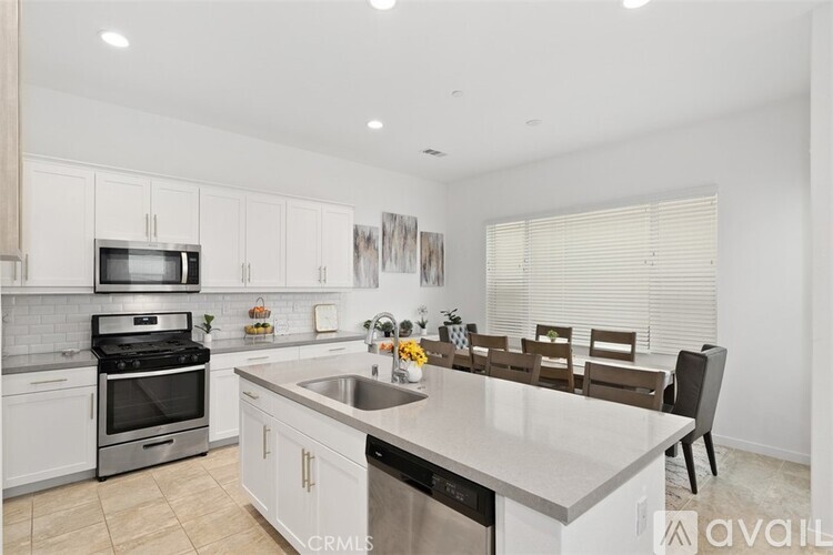 A kitchen with white cabinets and a large island.