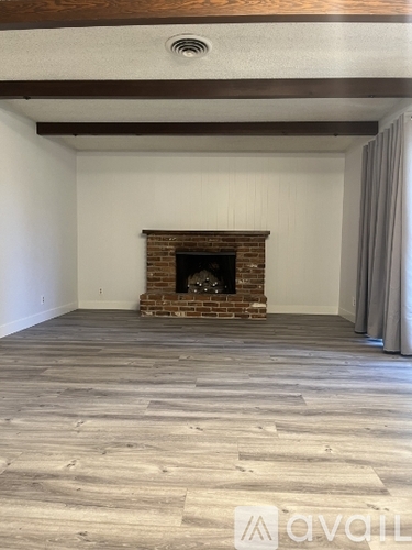 A room with a fireplace and wooden flooring.