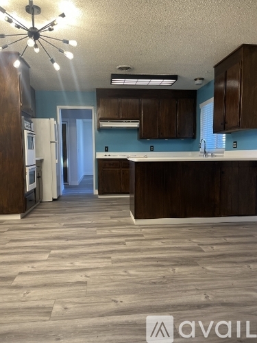A kitchen with wooden floors and cabinets.