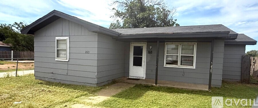 A grey house with a white door and window is for sale.