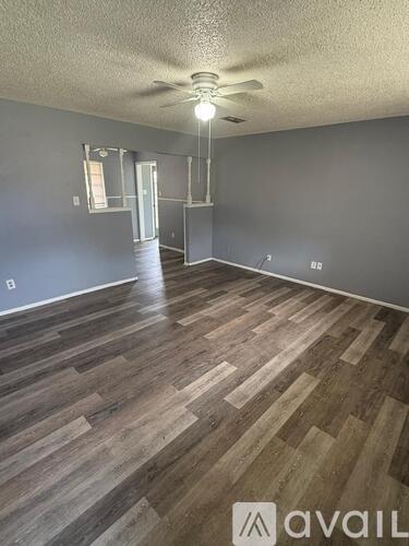 A room with wooden flooring and a ceiling fan.