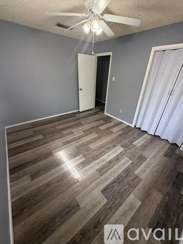 A room with wooden flooring and a ceiling fan.