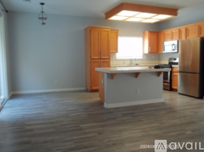 A kitchen with wooden cabinets and a white island.