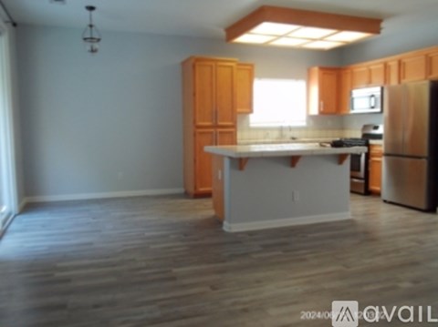 A kitchen with wooden cabinets and a white island.